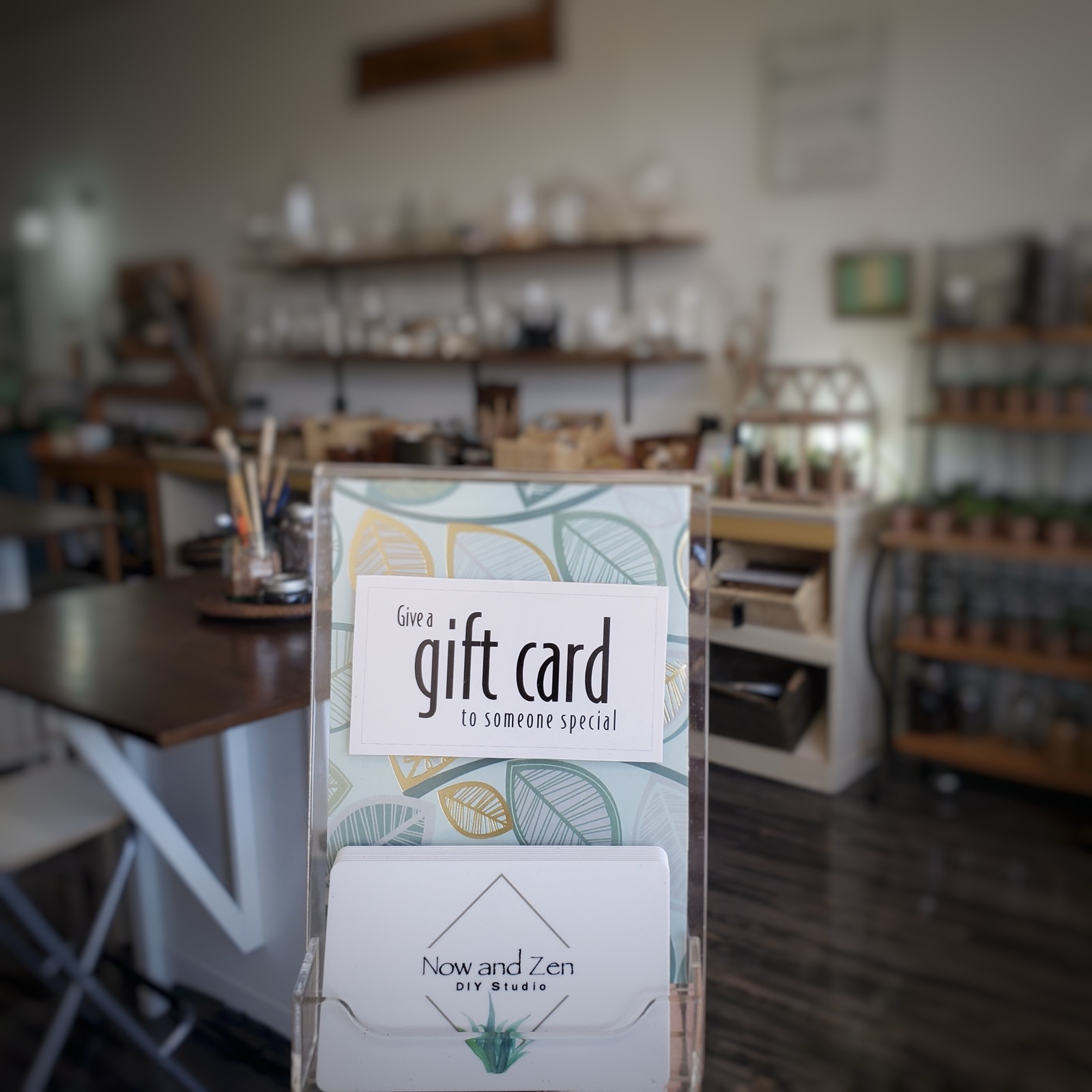 A Now and Zen gift card display standing on a table in the studio